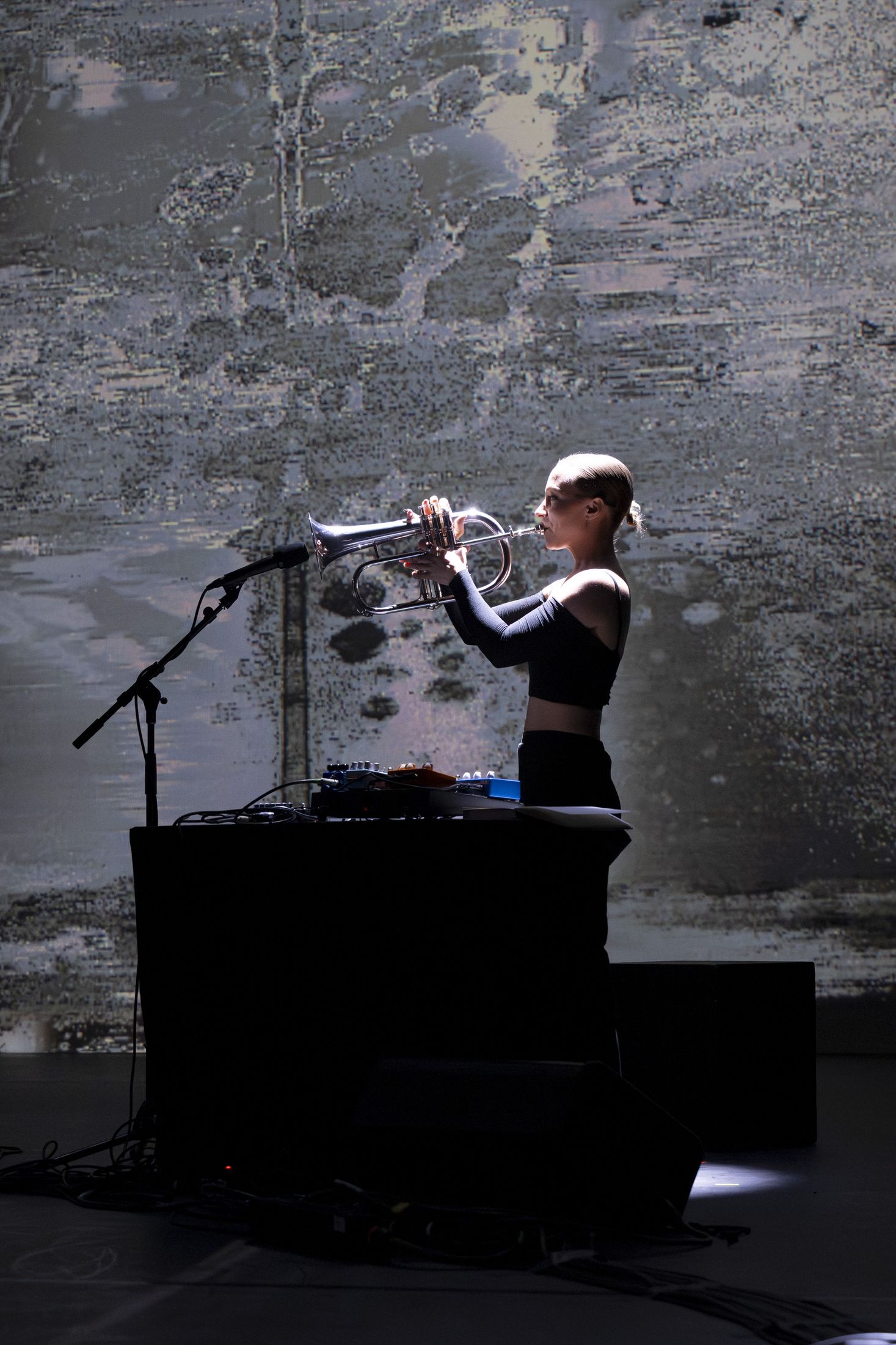 Briana Gillet on trumpet in front of the projection