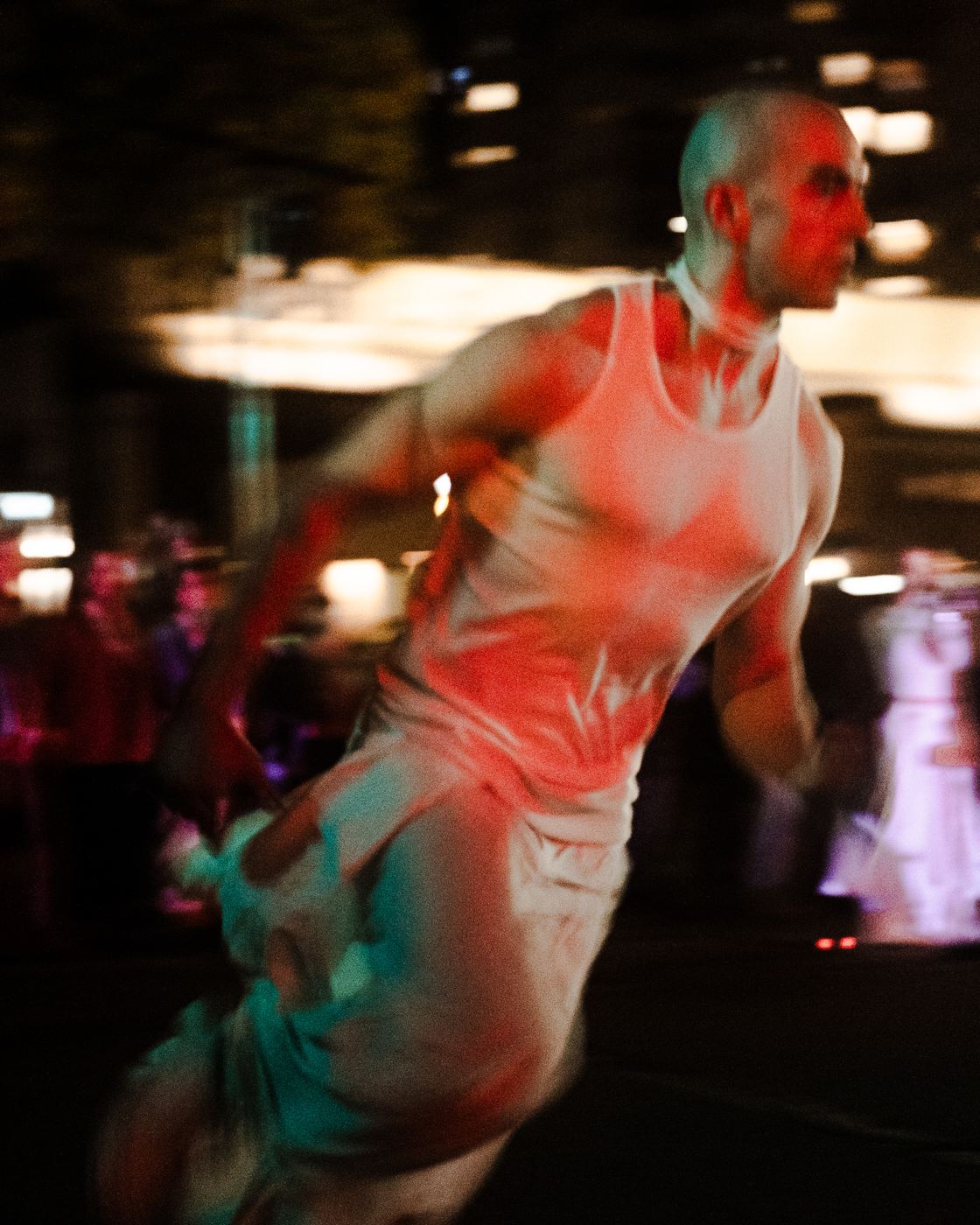 A dancer running, lit red, blurred