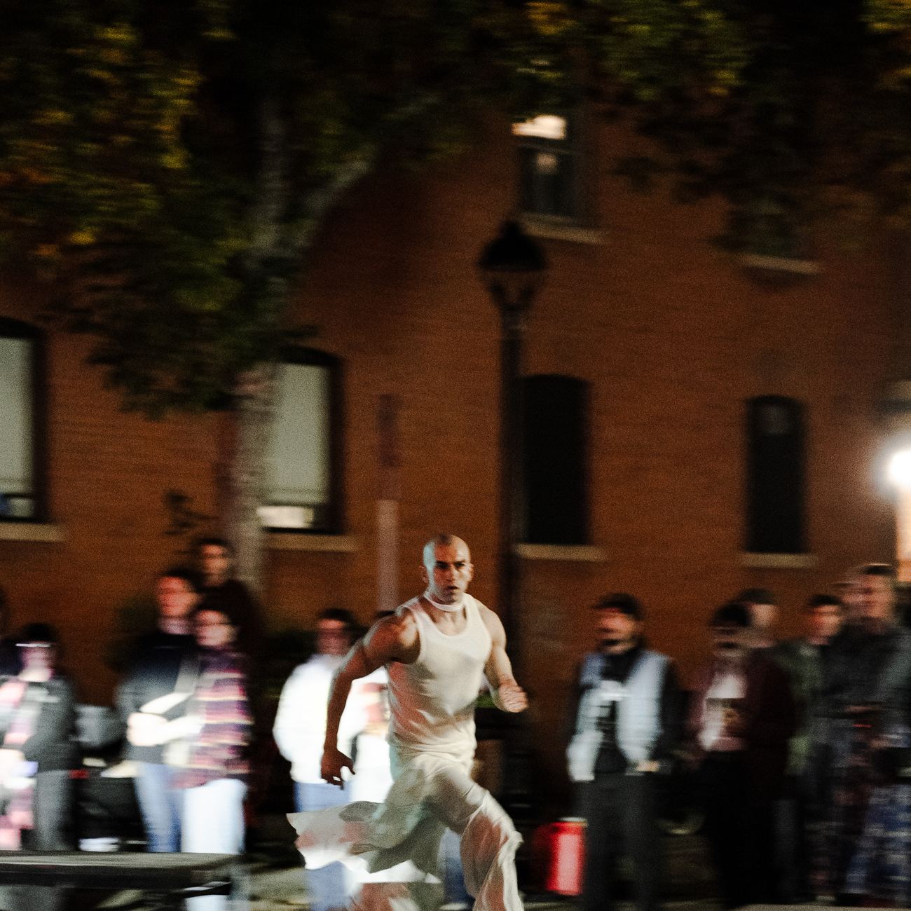 A dancer running across the street past the crowd