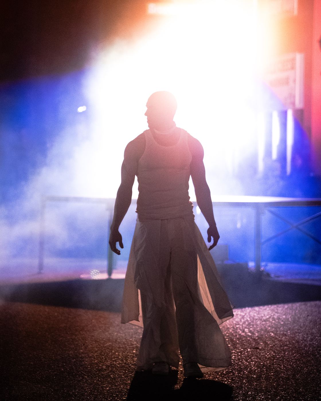 A dancer in silhouette against bright light and haze